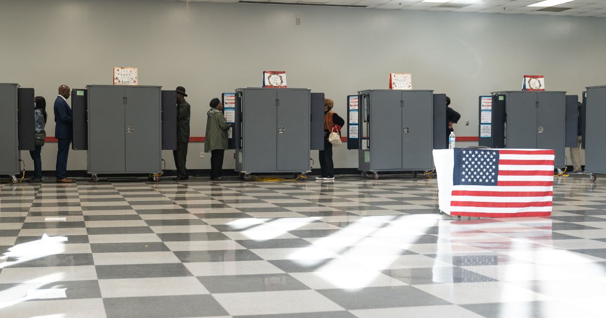 Democrat Sen. Raphael Warnock is pictured with other Georgian voters casting their early voting ballots on Monday in Atlanta.
