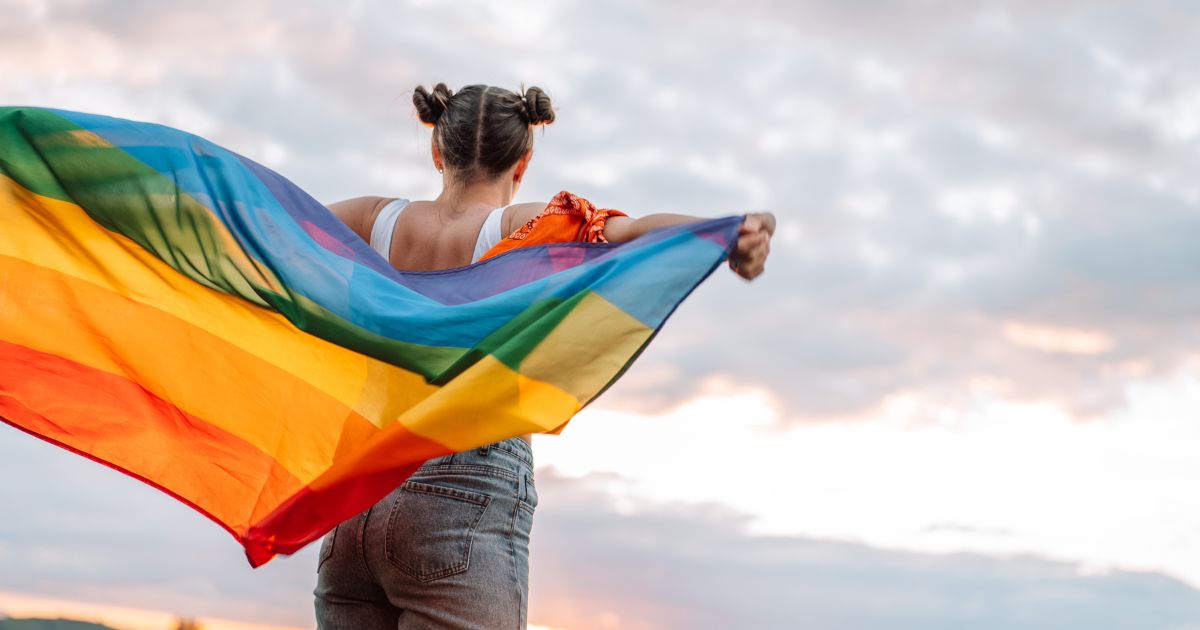 A girl holds an LGBT pride flag in this stock photo. The Biden administration openly supports a host of transgender medical procedures.