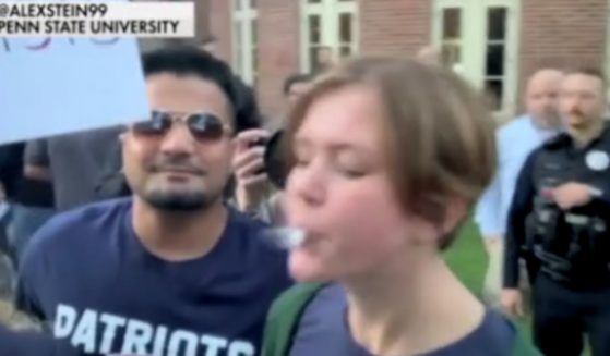 A Penn State student is pictured spitting on conservative comedian Alex Stein at an on-campus protest on Monday.