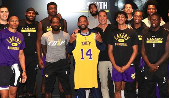 Actor Will Smith, center, poses with the Los Angeles Lakers at the team's facility.