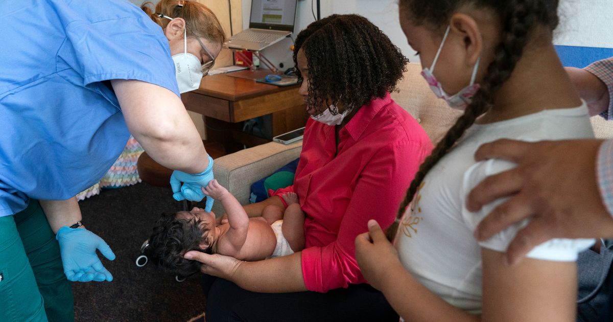 Olivia Isidoro watches her one-month-old baby sister Charlotte get checked out