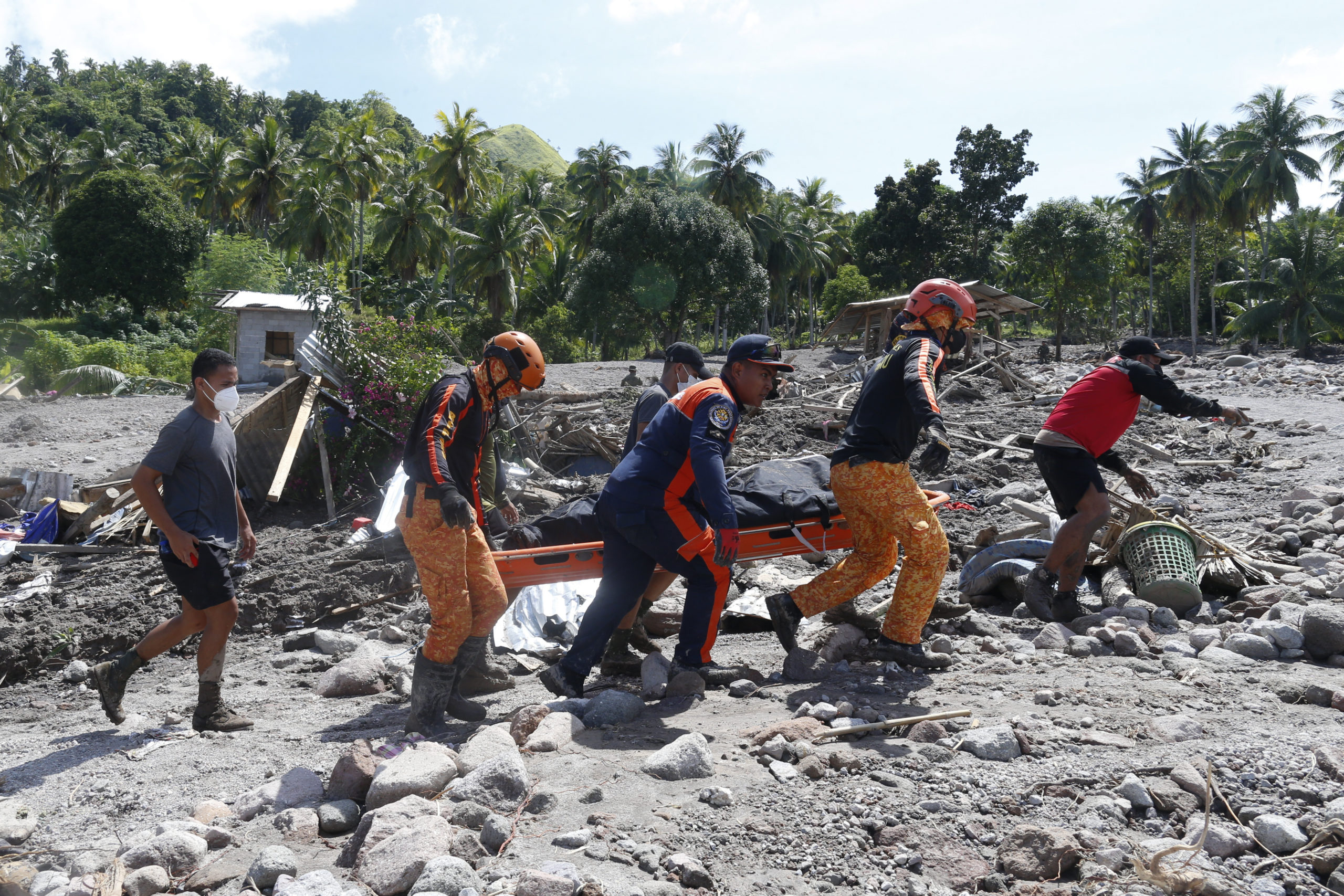 On Sunday, rescuers carry the body of a victim of mudslide in Maguindanao's Datu Odin Sinsuat town, Philippines.
