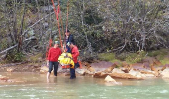Rescuers use a backboard to bring an injured New Mexico woman out of the wilderness in southwestern Colorado.