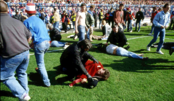 Stewards and supporters tend and care for wounded supporters on the field at Hillsborough Stadium, in Sheffield, England, on April 15, 1989.