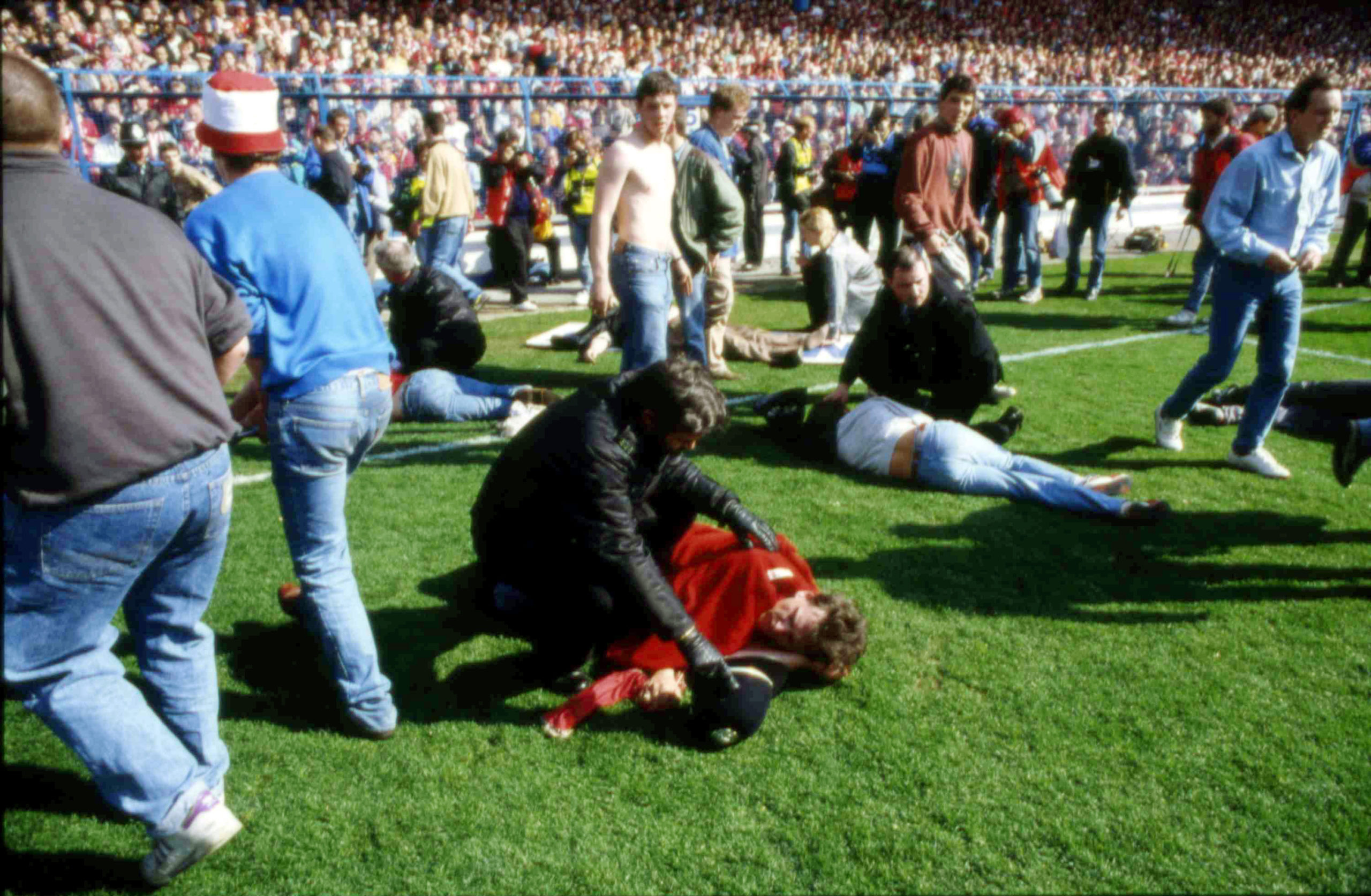 Stewards and supporters tend and care for wounded supporters on the field at Hillsborough Stadium, in Sheffield, England, on April 15, 1989.