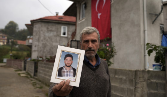 Recep Ayvaz, 62, shows a picture of his son, Selcuk Ayvaz, 33, one of the miners killed in a coal mine explosion, in front of his house in Amasra, in the Black Sea coastal province of Bartin, Turkey on Sunday.
