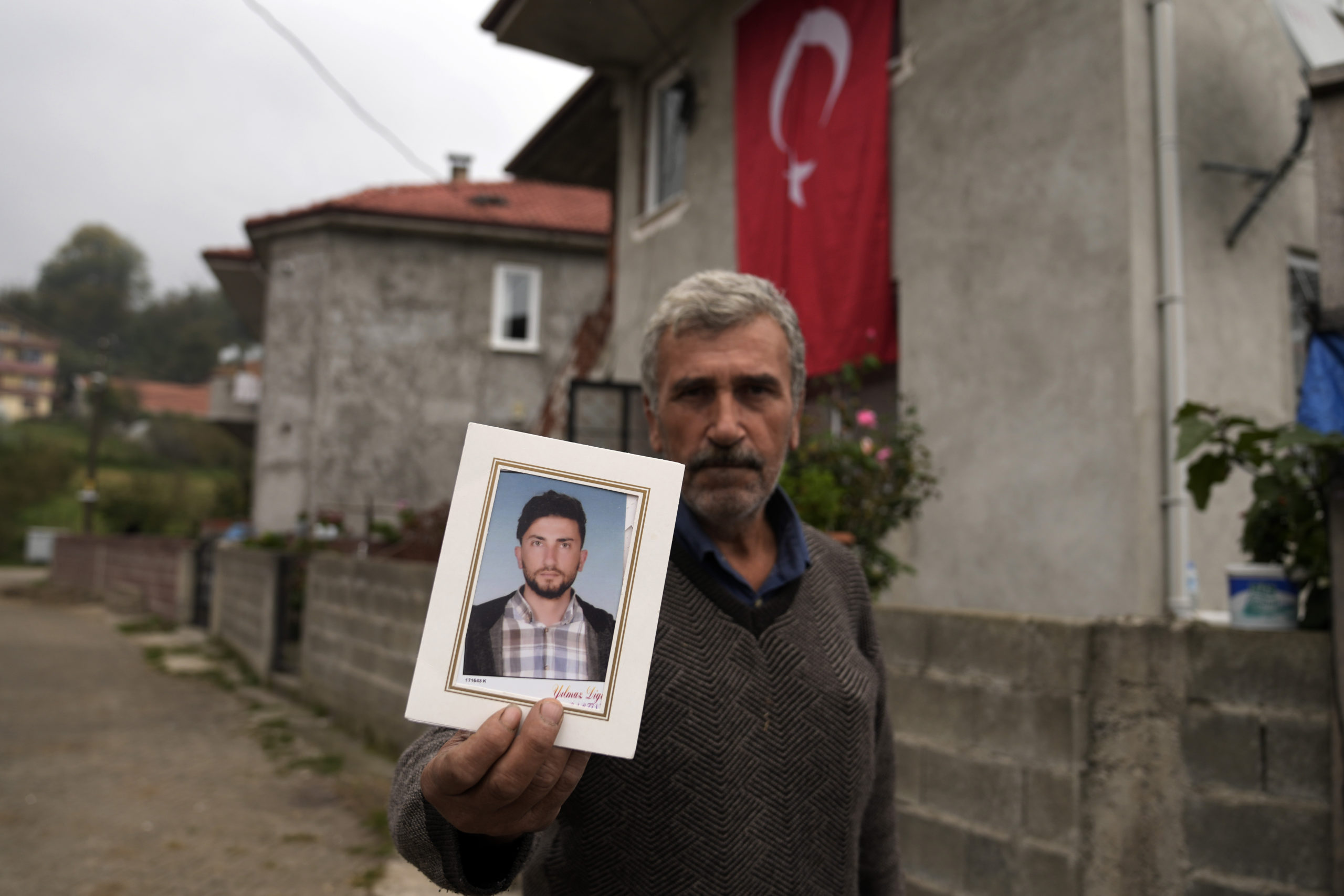 Recep Ayvaz, 62, shows a picture of his son, Selcuk Ayvaz, 33, one of the miners killed in a coal mine explosion, in front of his house in Amasra, in the Black Sea coastal province of Bartin, Turkey on Sunday.