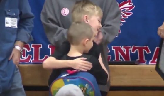 Two boys embrace after one saved the other from choking.