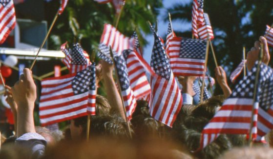 People wave the American flag at a political rally.