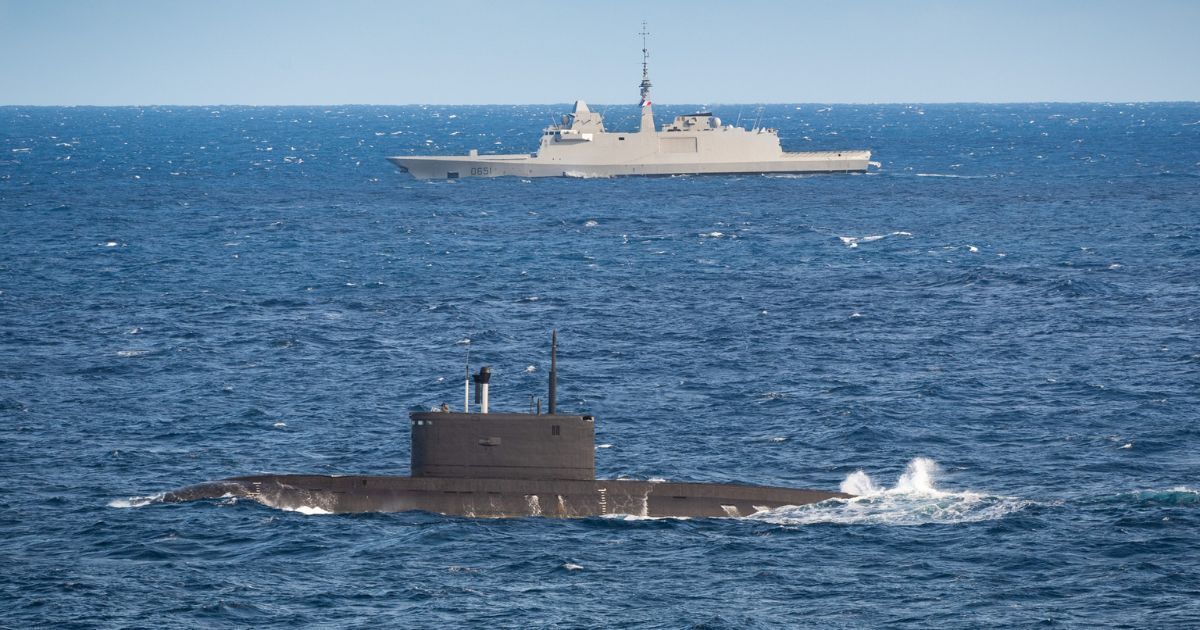 a French frigate escorting a Russian submarine