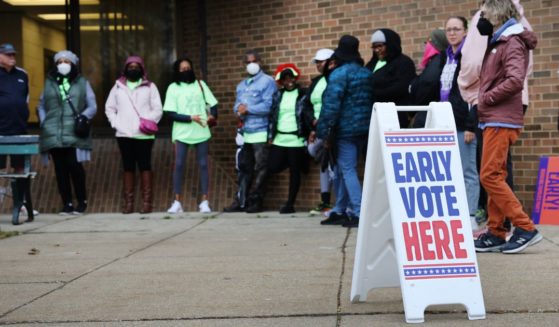 People wait in line outside a polling place on Oct. 25 in Milwaukee.