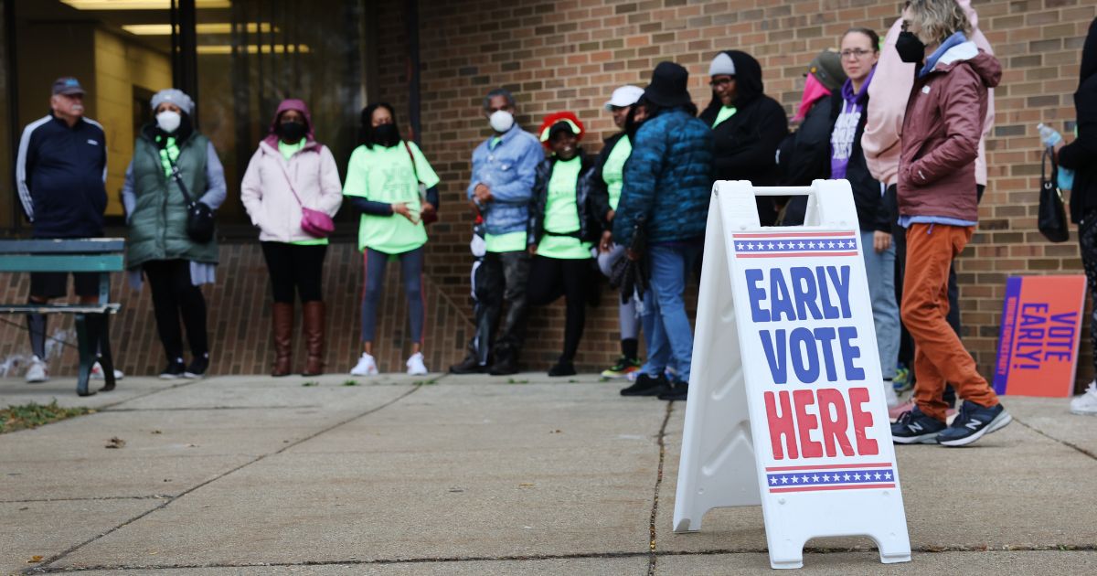 People wait in line outside a polling place on Oct. 25 in Milwaukee.