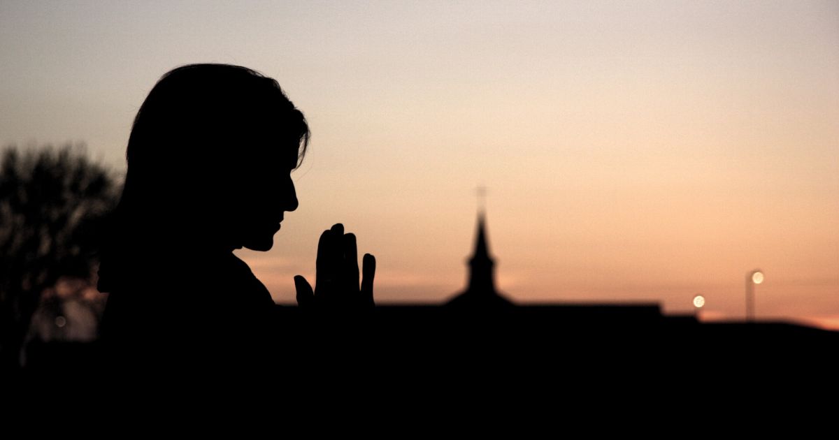 A woman prays in this stock image.