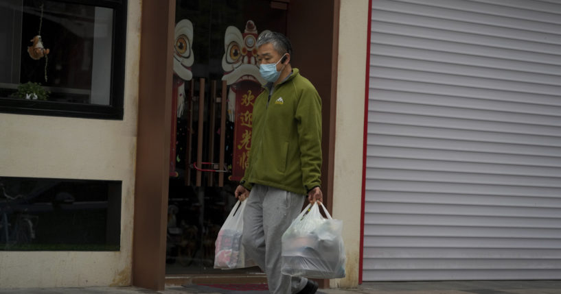 A man carries groceries along the street in Beijing, China, on Thursday.