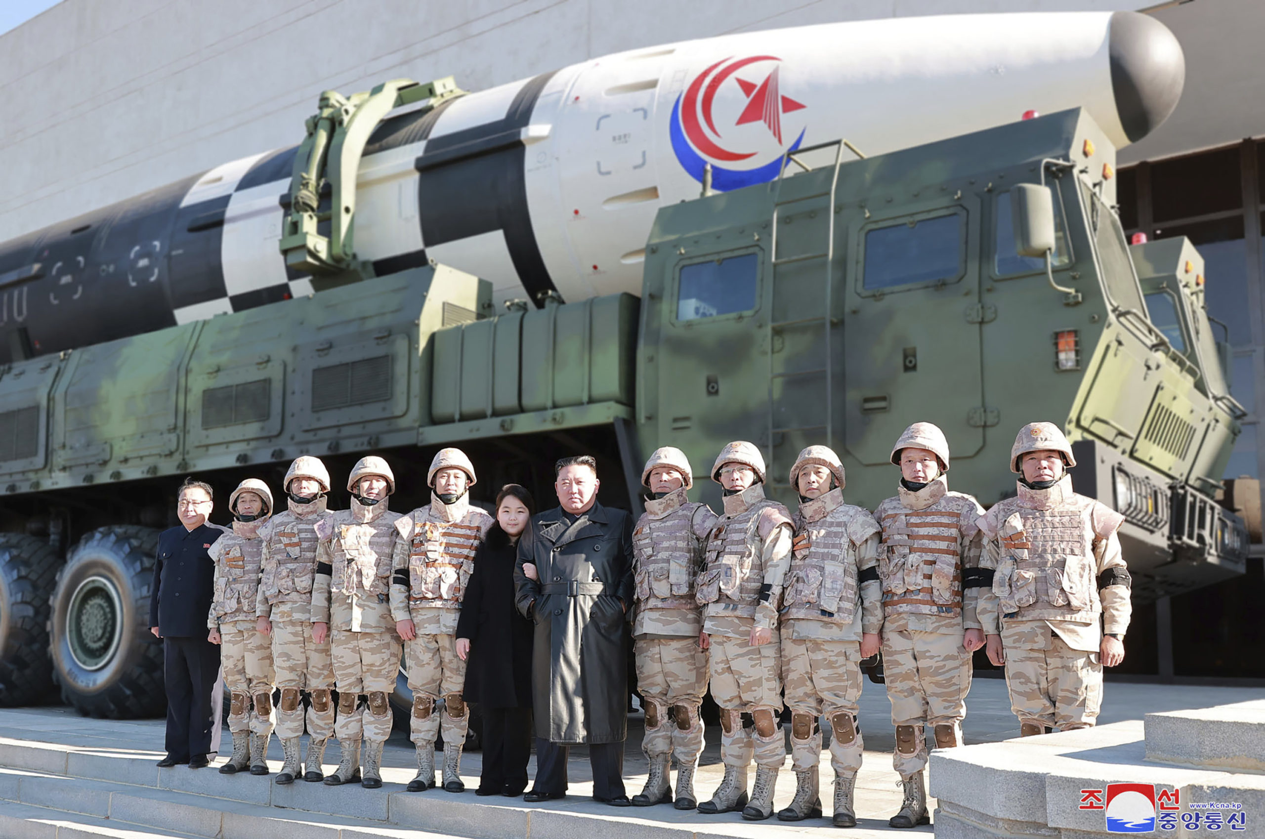 North Korean leader Kim Jong Un, center, and his daughter, center left, pose with soldiers in front of the Hwasong-17 intercontinental ballistic missile in North Korea.