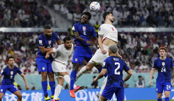 Players fight for a header during the World Cup group B soccer match between Iran and the United States in Doha, Qatar, on Tuesday.