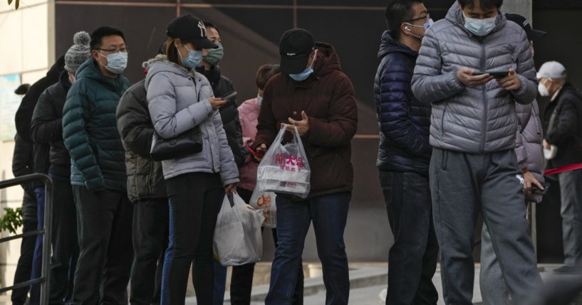 Beijing residents wait in line to enter a store on Sunday.