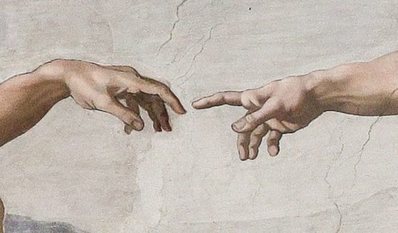 A detail of Michelangelo's "The Creation of Adam" is seen in the above stock image.