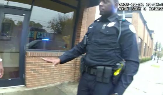Atlanta police officers approach a man in ill-fitting clothing.
