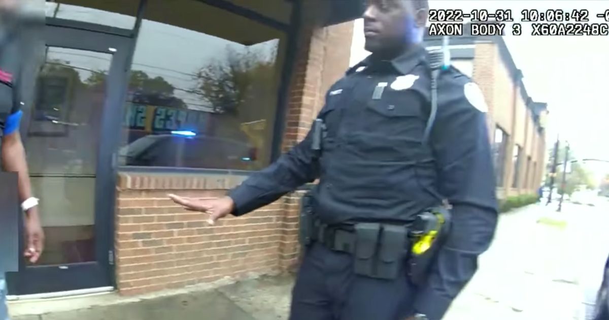 Atlanta police officers approach a man in ill-fitting clothing.