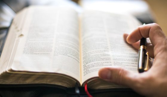 A man reads the Bible in the above stock image.