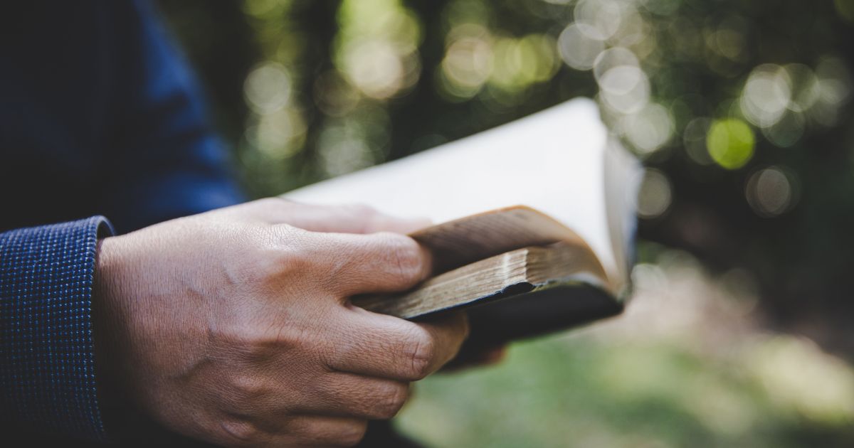 A person reads the Bible in the above stock image.