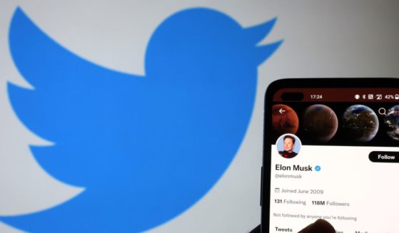 The Twitter account of Elon Musk is displayed on a smartphone with a Twitter logo in the background on Monday in Newcastle Under Lyme, England.