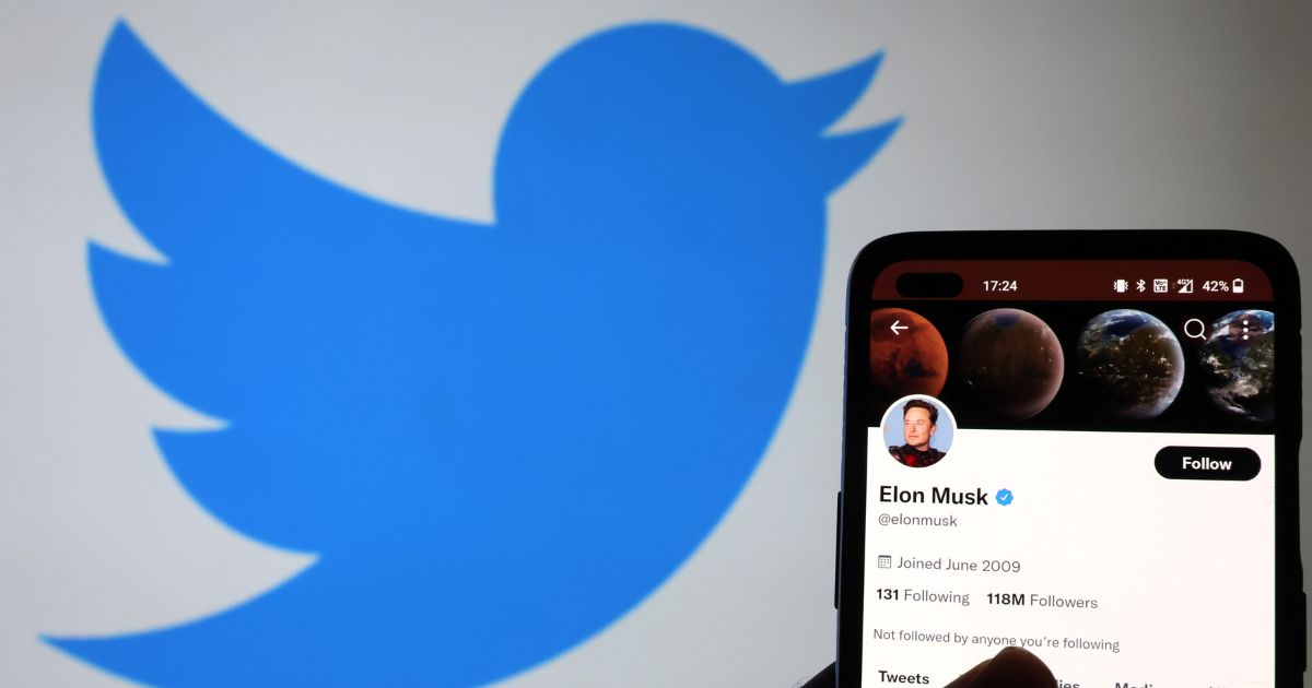 The Twitter account of Elon Musk is displayed on a smartphone with a Twitter logo in the background on Monday in Newcastle Under Lyme, England.