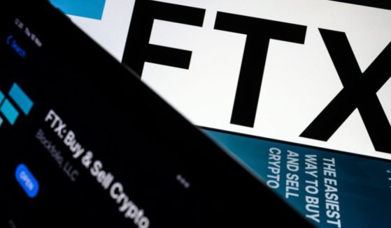 The FTX logo and mobile app are displayed on screens on Nov. 10 in London.