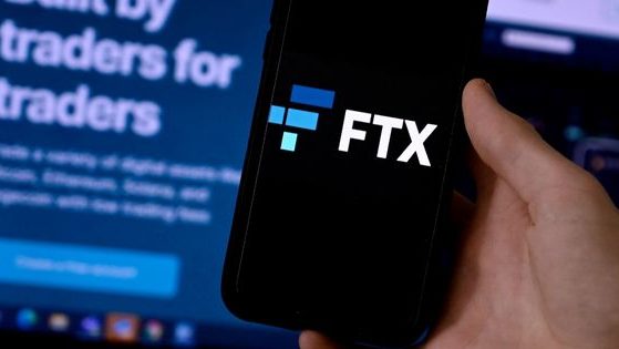 The FTX logo is displayed on a smart phone screen with the FTX website shown in the background.