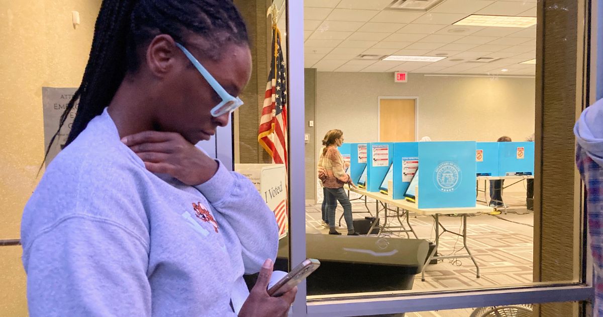 Jocelyn Elston of Lithonia, Georgia, waits in line to vote as people cast ballots during early voting inside a library in the Atlanta suburb of Tucker on Friday.