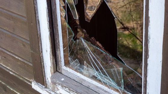 A home window pane is smashed in this stock photo.