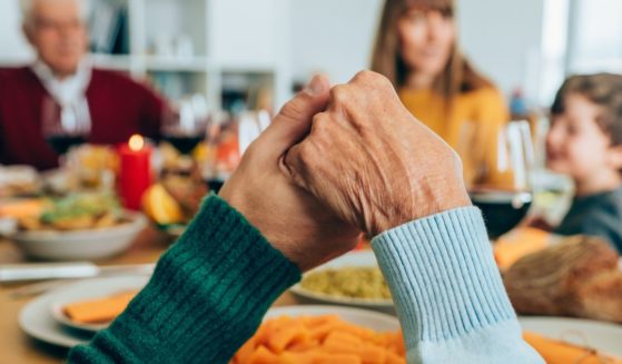People pray before a Thanksgiving meal in this stock image.