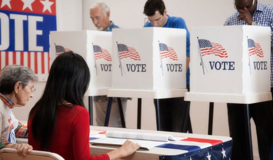 Stock photo of voters at a polling place.
