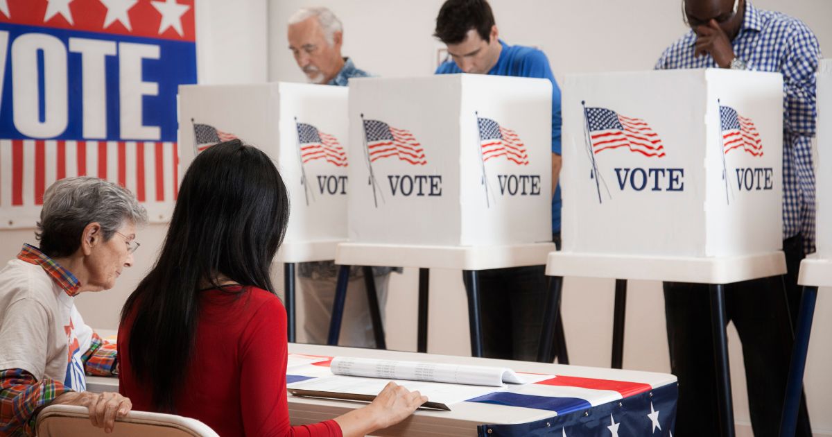 Stock photo of voters at a polling place.