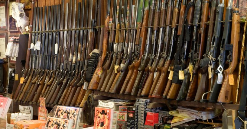 Guns are displayed on racks in a store.