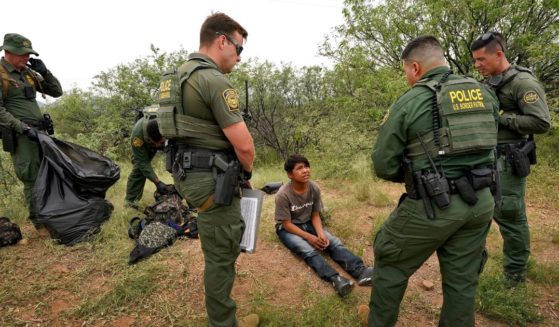 U.S. Border Patrol agents question a 12-year-old migrant boy after apprehension at the base of the Baboquivari Mountains near Sasabe, Arizona, on Sept. 8.