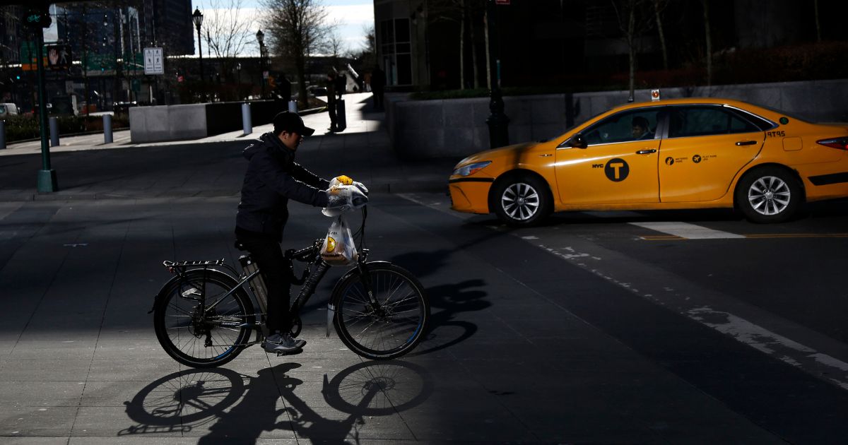 A man making deliveries rides an electric bike in New York City on Dec. 21, 2017.