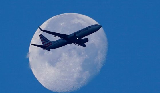 An American Airline Boeing 737 flies past the moon as it heads to Orlando, Florida, from Miami International Airport in Miami on April 19.
