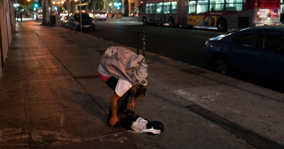 Anthony Delio falls asleep on a sidewalk after smoking fentanyl in Los Angeles, California, on Aug. 23.