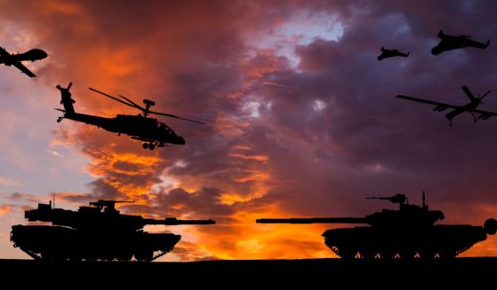 Armored tanks, combat drones and missile launchers are pictured at sunset.