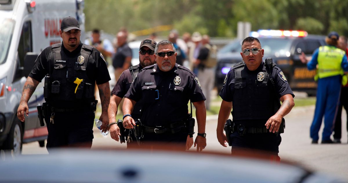 Police walk near Robb Elementary School in Uvalde, Texas, after the mass shooting there on May 24.