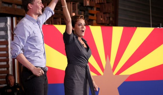 Arizona Republican gubernatorial candidate Kari Lake, right, and Arizona U.S. Senate candidate Blake Masters, left, raise their arms at a campaign rally in Queen Creek, Arizona, on Saturday.