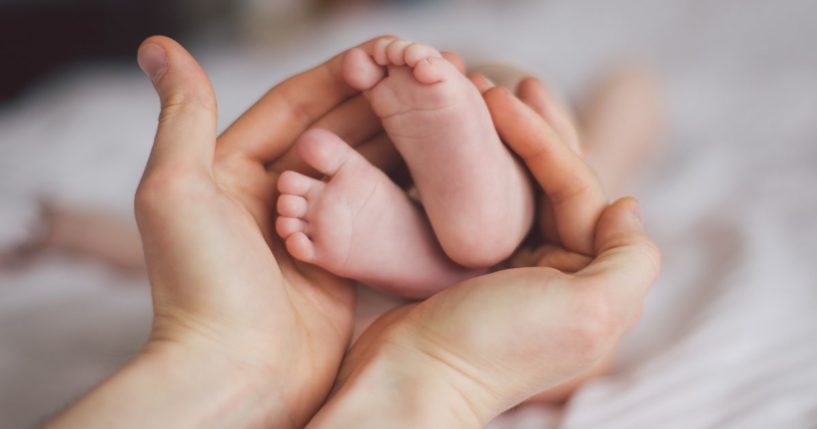 A mother holds her baby's feet in this stock image.