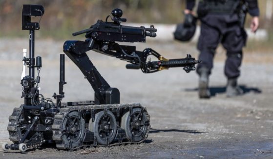 Police SWAT officer uses a mechanical arm bomb disposal robot unit in this stock image.