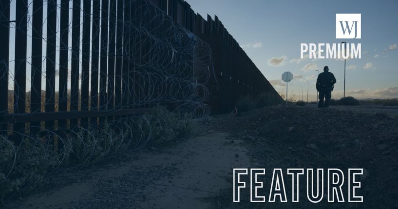 A U.S. Border Patrol agent searches for illegal migrants by the U.S.-Mexico border fence on Saturday near Douglas, Arizona.
