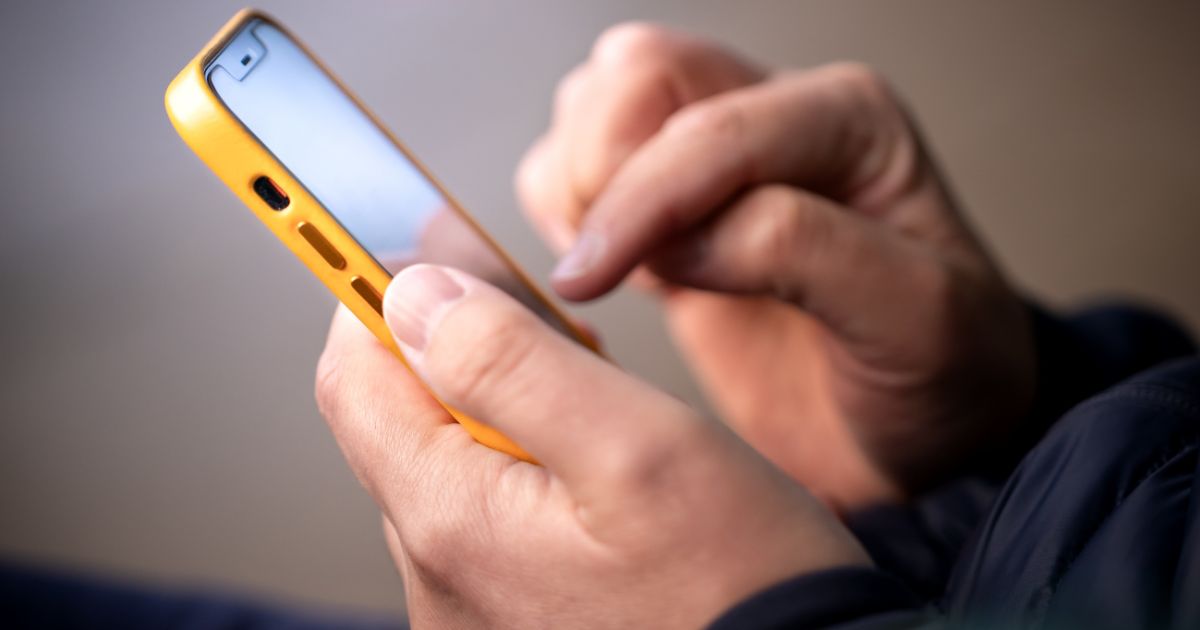 A man uses a cellphone in the above stock image.