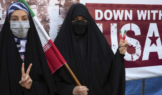 Iranian women flash a victory sign during an annual demonstration in front of the former U.S. Embassy in Tehran, Iran, on Friday.
