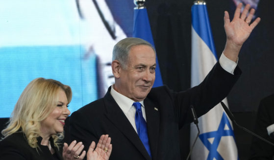 Benjamin Netanyahu, former Israeli Prime Minister and the head of the Likud party, is accompanied by his wife Sara as he waves to his supporters after the first exit poll results for the Israeli Parliamentary election at his party's headquarters in Jerusalem, Israel, on Wednesday.