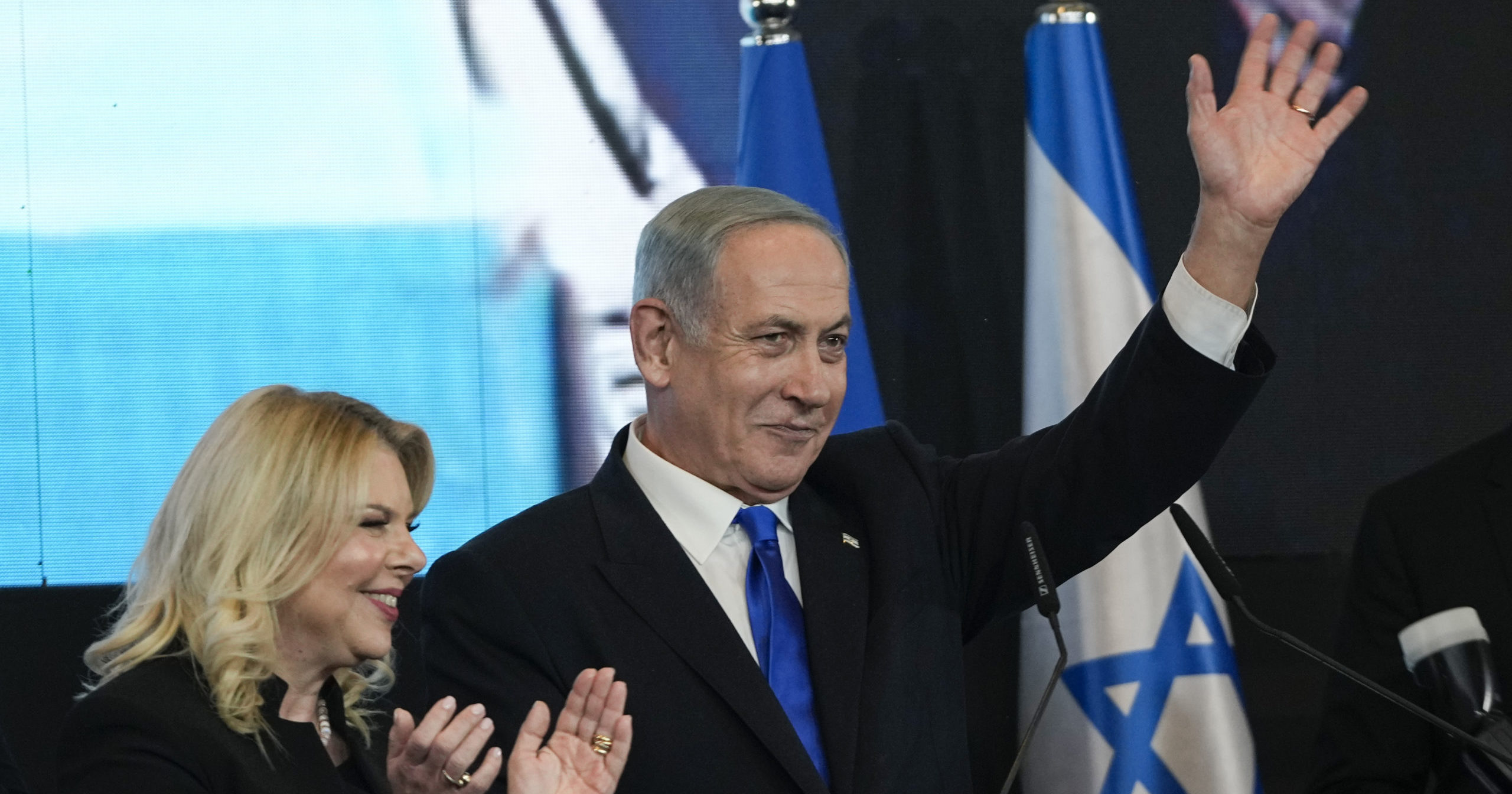 Benjamin Netanyahu, former Israeli Prime Minister and the head of the Likud party, is accompanied by his wife Sara as he waves to his supporters after the first exit poll results for the Israeli Parliamentary election at his party's headquarters in Jerusalem, Israel, on Wednesday.